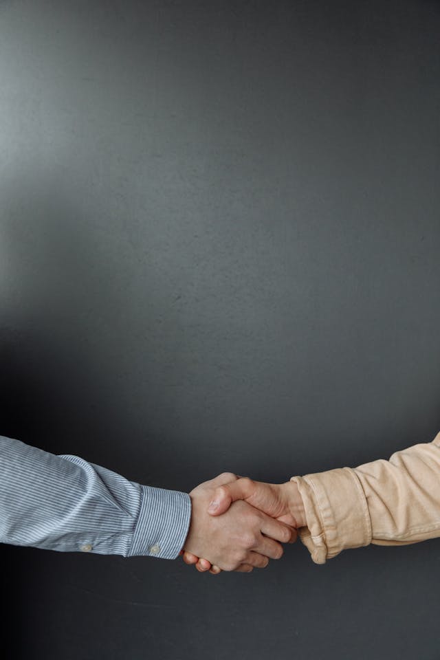 Une poignée de main entre deux personnes illustre une relation de confiance et un partenariat durable autour des services généraux.